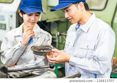 A group of workers inspecting products in a factory A group of workers inspecting products in a factory 126813707