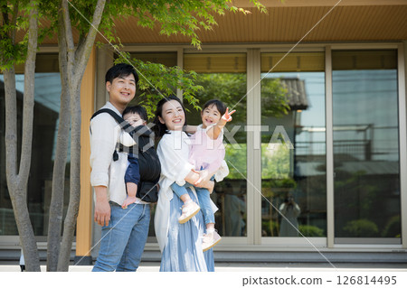 Mom and dad holding their child in front of their house, looking towards the future and hopes Mom and dad holding their child in front of their house, looking towards the future and hopes 126814495