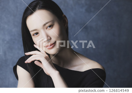 A woman wearing a black off-the-shoulder 126814549