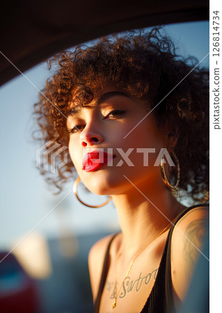 A woman with red lipstick and gold hoop earrings is posing for a photo A woman with red lipstick and gold hoop earrings is posing for a photo 126814734