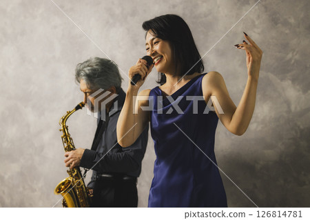 A man playing saxophone and a woman singing A man playing saxophone and a woman singing 126814781