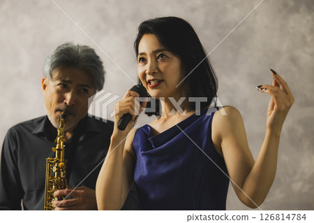 A man playing saxophone and a woman singing 126814784