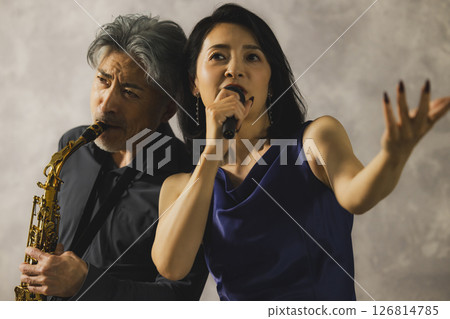 一名男子吹奏薩克斯，一名女子唱歌 126814785