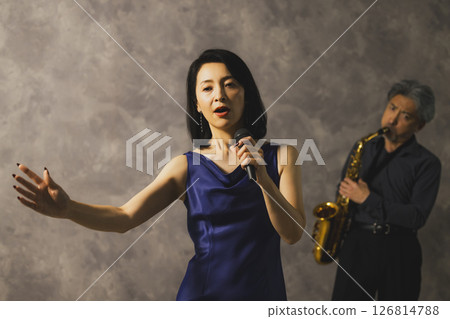 一名男子吹奏薩克斯,一名女子唱歌 一名男子吹奏薩克斯,一名女子唱歌 126814788