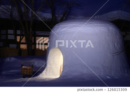 Snow-covered old house and snow igloos Snow-covered old house and snow igloos 126815309