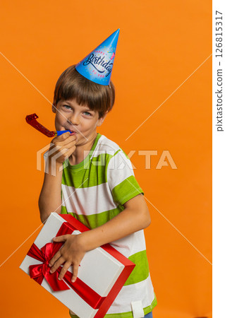 Happy excited lucky boy wearing birthday hat cone blow pipe celebrating party success win victory 126815317