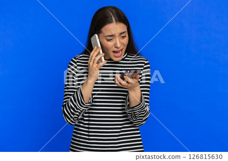 Irritated stressed business woman talking on two mobile phones having conversation conflict quarrel 126815630