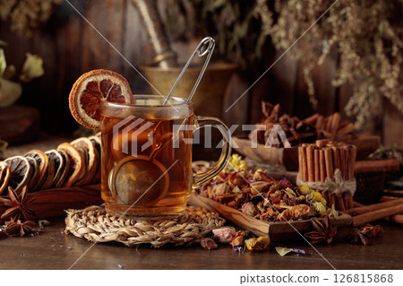 Cup of herbal tea with various dried herbs, flowers, and spices. 126815868
