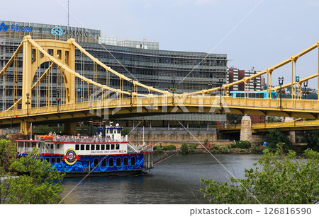 Bright Yellow Bridge Spans River With a Tour Boat Below in the City of Pittsburgh 126816590
