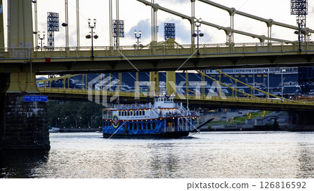 Ferry Navigating Under a Bridge in a Bustling Riverside City of Pittsburgh Ferry Navigating Under a Bridge in a Bustling Riverside City of Pittsburgh 126816592
