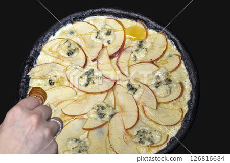 Pizza from black dough with cuttlefish ink pear blue cheese and honey. 126816684