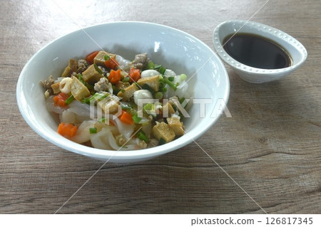 steamed large rice noodles topping chop pork and dice tofu with carrot dressing black soy sauce on plate  126817345