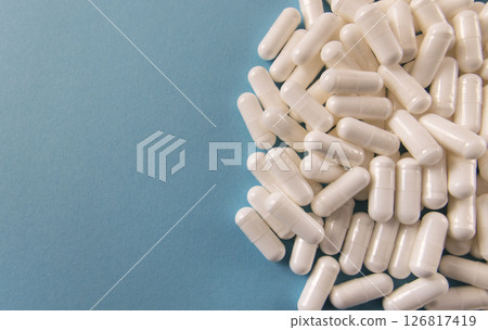 Much medical yellow pills and drugs in transparent package on the blue paper background. Healthcare concept. BAA or biologically active additives. Much medical yellow pills and drugs in transparent package on the blue paper background. Healthcare concept. BAA or biologically active additives. 126817419