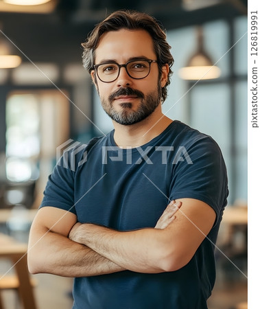 confident startup founder standing in coworking space, arms crossed, 126819991