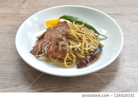 fried spaghetti topping crispy pork bacon and slice dry chili with bell pepper on plate    126820181