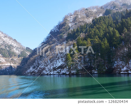 Snowy mountain scenery seen from a sightseeing boat on a winter morning in Shogawa Gorge 126820434