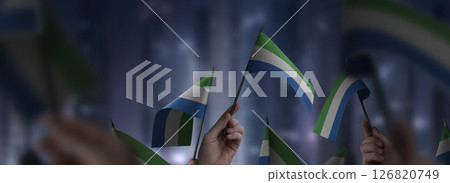 Sierra Leone flags in their hands on a blurred urban background Sierra Leone flags in their hands on a blurred urban background 126820749