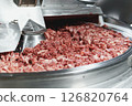 Processing of production minced meat in industrial meat grinder, close up. 126820764