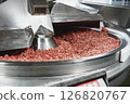 Processing of production minced meat in industrial meat grinder, close up. 126820767