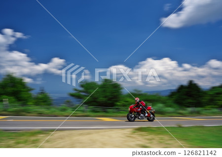 A red bike touring under the white clouds and blue sky of Aoyama Plateau in early summer A red bike touring under the white clouds and blue sky of Aoyama Plateau in early summer 126821142