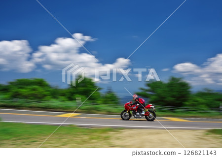 初夏青山高原的白雲藍天下,紅色的自行車在行駛 初夏青山高原的白雲藍天下,紅色的自行車在行駛 126821143