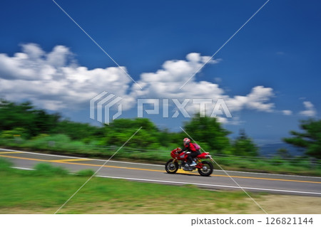 初夏青山高原的白雲藍天下，紅色的自行車在行駛 126821144