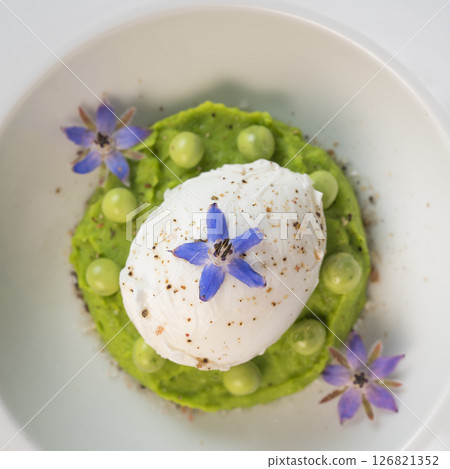 Delicious fresh pea puree topped with a perfectly poached egg and garnished with borage flowers for 126821352