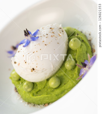 Delicious fresh pea puree topped with a perfectly poached egg and garnished with borage flowers for 126821353