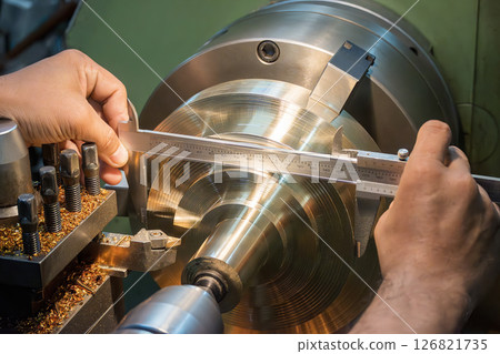 Close up scene the machine operator measuring diameter of turning parts by Vernier caliper. Close up scene the machine operator measuring diameter of turning parts by Vernier caliper. 126821735