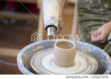 Clay vase on a potter's wheel. Working with clay Clay vase on a potter's wheel. Working with clay 126822058
