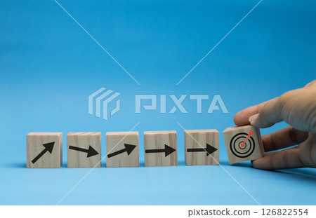 Concept of wooden blocks with arrows shooting straight to the target. Concept of wooden blocks with arrows shooting straight to the target. 126822554