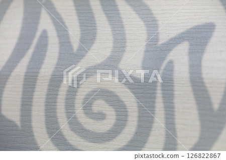 Concrete wall with a beautiful shadow from a geometric figure with curls. 126822867