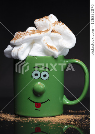 Funny green cup with a cheerful face with whipped cream. An invigorating drink in the morning. 126822876