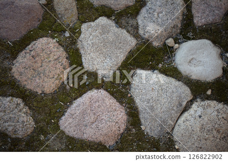 Background of an old wall made of rough large stones, boulders and moss. Background of an old wall made of rough large stones, boulders and moss. 126822902