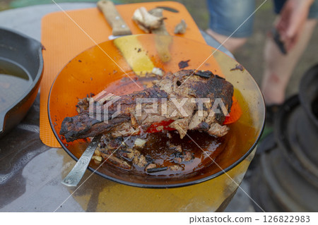 Fish fried in a pan is on a plate. 126822983