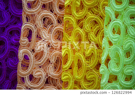 Guipure multi-colored fabrics of the same texture. Textile production. Guipure multi-colored fabrics of the same texture. Textile production. 126822994