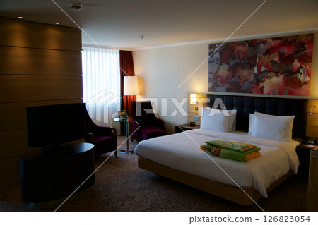 Mainz, Germany, July 8, 2017: Hotel Room with Double Bed and Red Lounge Chair Mainz, Germany, July 8, 2017: Hotel Room with Double Bed and Red Lounge Chair 126823054