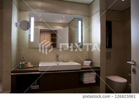 Mainz, Germany, July 8, 2017: Hotel Bathroom with Sink, Mirror, and Bright Tiles Mainz, Germany, July 8, 2017: Hotel Bathroom with Sink, Mirror, and Bright Tiles 126823061