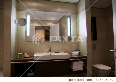 Mainz, Germany, July 8, 2017: Hotel Bathroom with Sink, Mirror, and Bright Tiles Mainz, Germany, July 8, 2017: Hotel Bathroom with Sink, Mirror, and Bright Tiles 126823079
