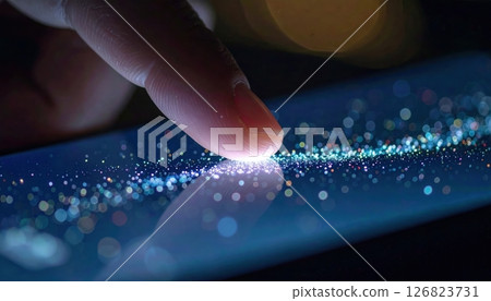 Close-up of a fingertip touching a glowing surface with tiny illuminated particles and bokeh effect in dark environment 126823731