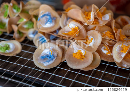 Colorful Khanom Buang, known as Thai crepe or crispy pancake with creamy topping made from egg whites and topped with egg yolk threads. It is a popular street food. 126824659