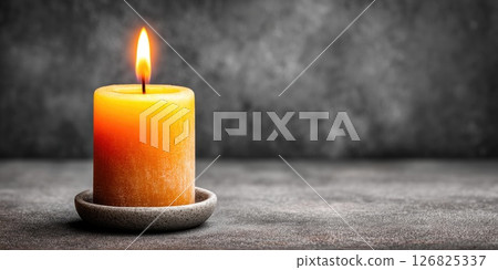Burning Yellow Candle in Ceramic Holder on Dark Background 126825337
