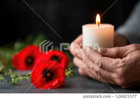 Memorial Tribute with Candle and Red Poppies 126825377