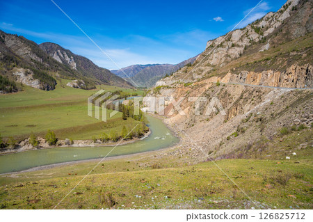 Aerial view of Chuya River flowing between mountains in Chuysky Trakt area Altai Russia. Scenic Siberian river valley surrounded by rugged terrain. Aerial view of Chuya River flowing between mountains in Chuysky Trakt area Altai Russia. Scenic Siberian river valley surrounded by rugged terrain. 126825712