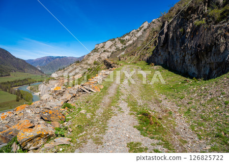 Ancient road near Chuysky Trakt Altai Russia once part of the Silk Road. Historic trade route crossing mountainous Siberian landscape. Ancient road near Chuysky Trakt Altai Russia once part of the Silk Road. Historic trade route crossing mountainous Siberian landscape. 126825722