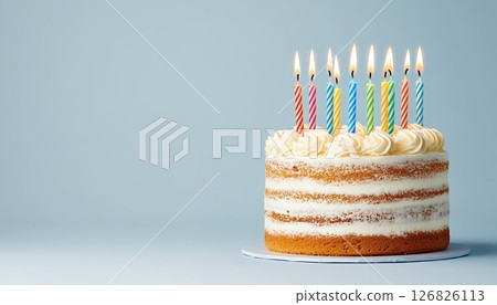 Layered Vanilla Birthday Cake with Colorful Candles on Light Blue Background 126826113