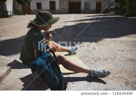 Traveler Relaxing in a Historic Spanish Village While Consulting a Map 126826490