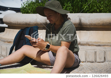 Traveler Using Smartphone for Navigation While Exploring a Scenic Medieval Setting 126826493