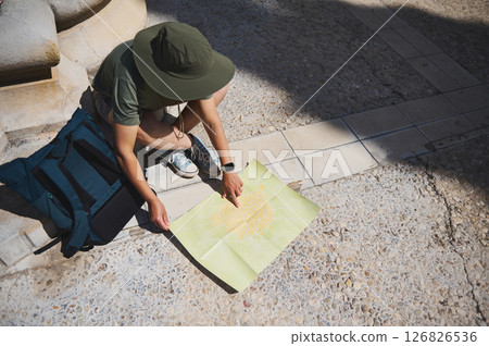 Traveler Exploring a Historic Town Street With a Map Traveler Exploring a Historic Town Street With a Map 126826536