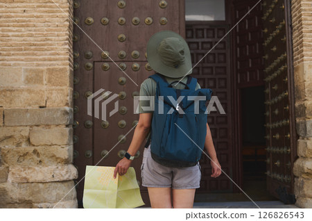 Adventurer Exploring a Historic City with Backpack and Map Adventurer Exploring a Historic City with Backpack and Map 126826543